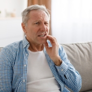 Portrait of unhappy mature man suffering from toothache