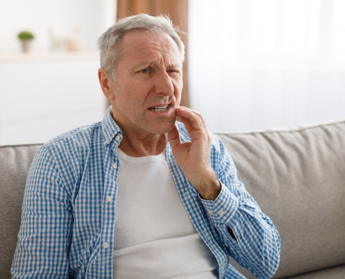 Portrait of unhappy mature man suffering from toothache